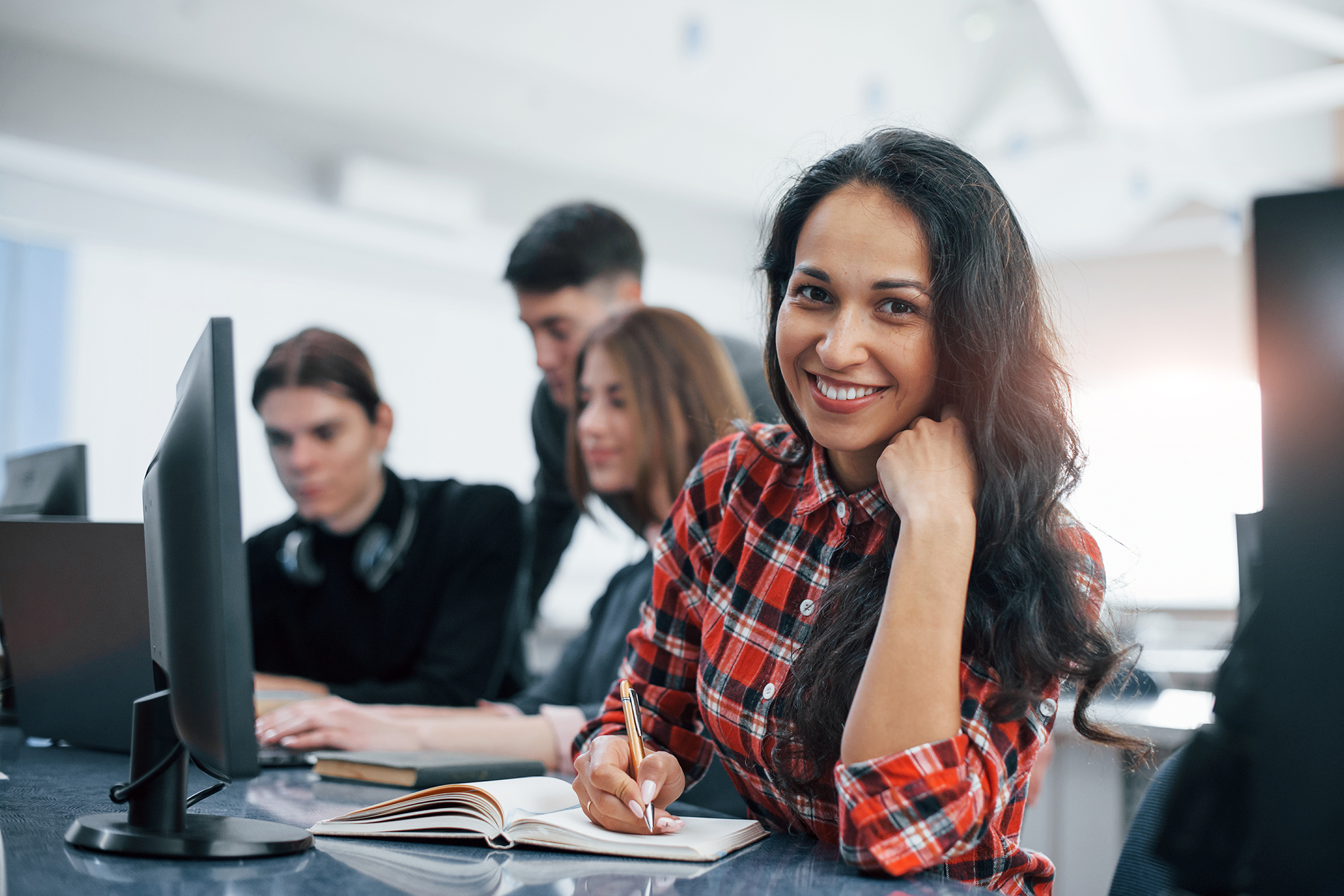 Cheerful brunette. Group of young people in casual clothes working in the modern office.